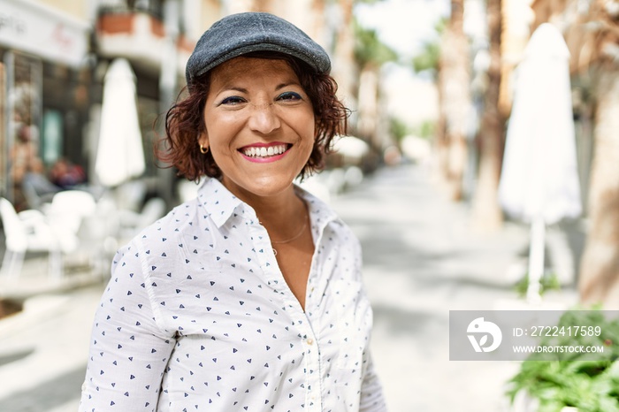 Middle age latin woman smiling happy standing at the city.