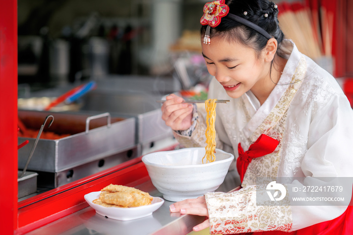 Korean girl eat a noodle with Korean traditional dress in old and vintage restaurant