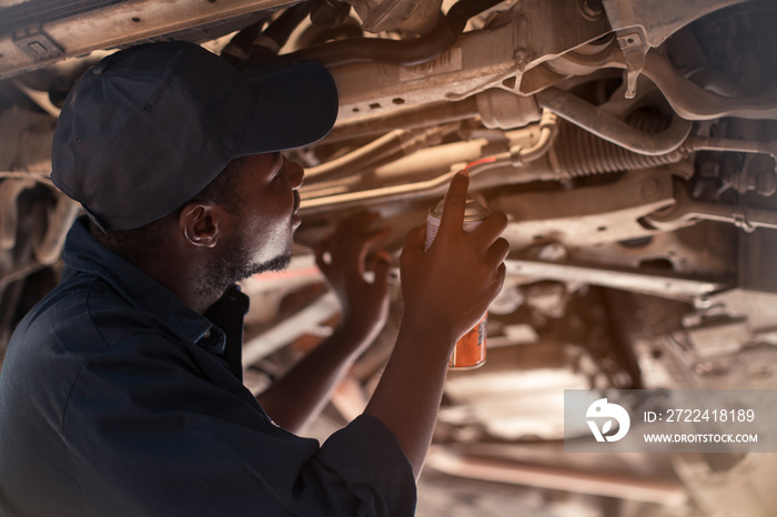 African maintenance male checking car, service via insurance system at garage