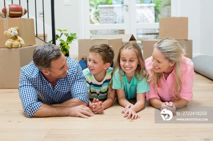 Parents and kids lying on floor in living room