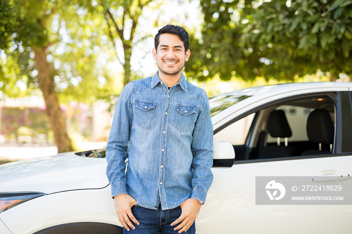 Handsome latin man standing by his car