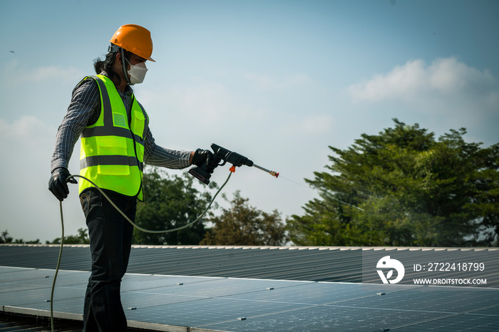 Maintenance technician using high pressure water to clean the solar panels that are dirty with dust to improve the efficiency of solar energy storage.