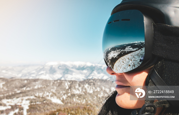 Close up skiers female person goggles with mountains panorama reflection. Ski holiday in caucasus mountains