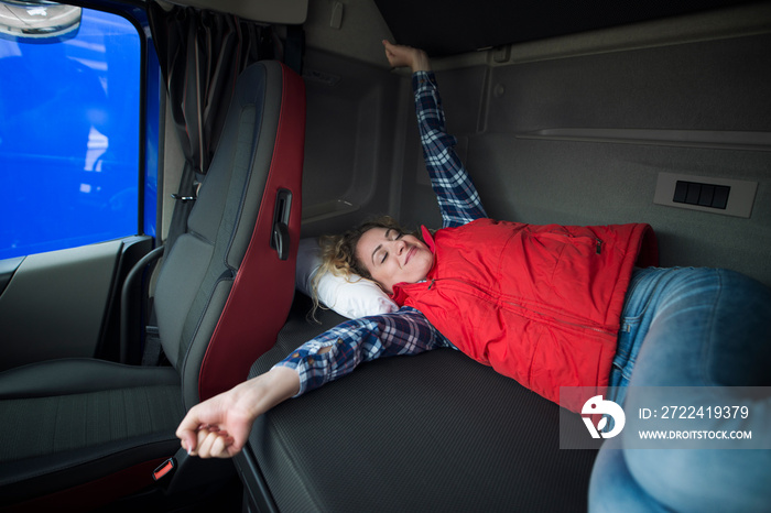 Truck driver lifestyle. Trucker waking up in his cabin after a long ride.Truck cabin interior with driver sleeping in bed.