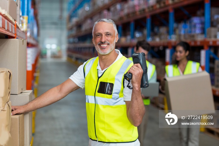 Portrait of smiling warehouse worker scanning box