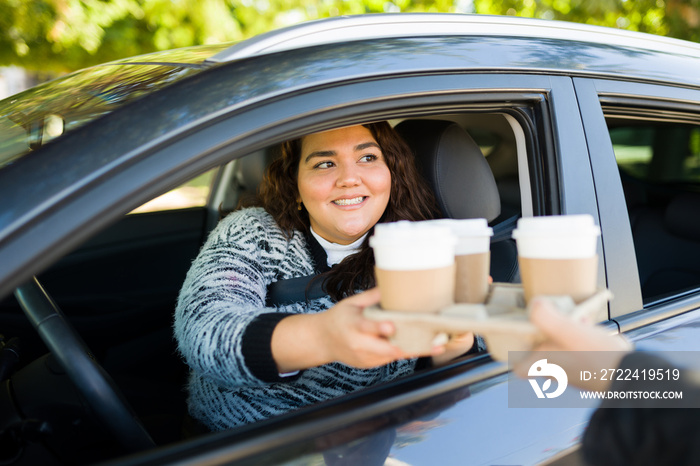 Happy big woman buying coffee in the drive thru