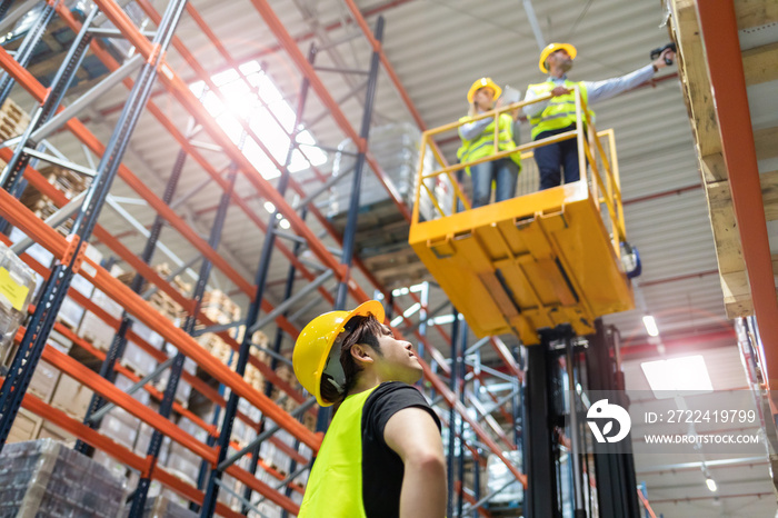 Warehouse workers on the height using lift work platform to check inventory