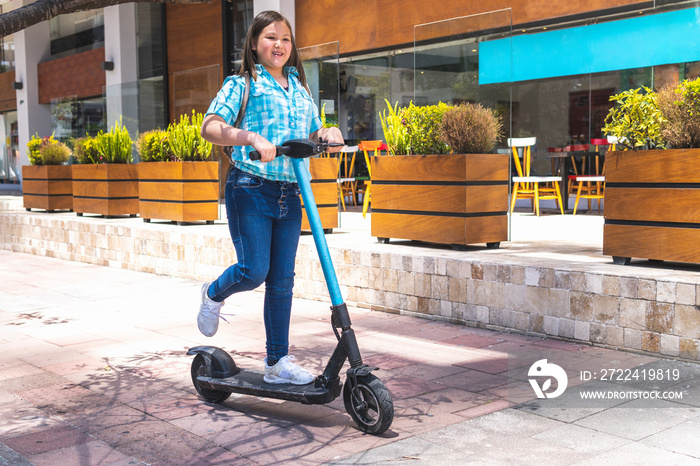 Blonde girl on the way to school on electric scooter