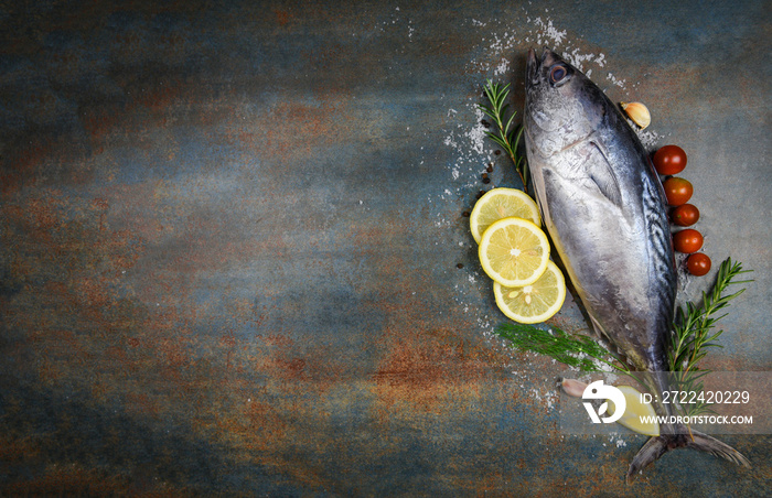 Fresh fish with herbs spices rosemary tomato and lemon - Raw fish seafood on black plate background , Longtail tuna , Eastern little tuna fish