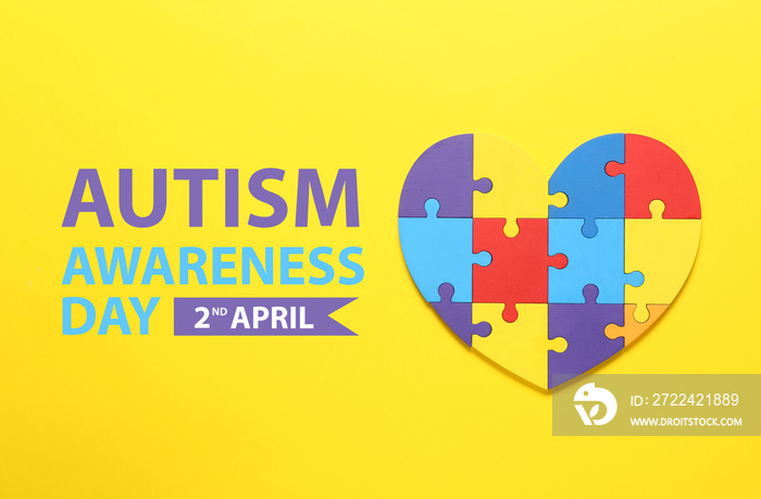 Colorful puzzle pieces in shape of heart on yellow background. World Autism Awareness day