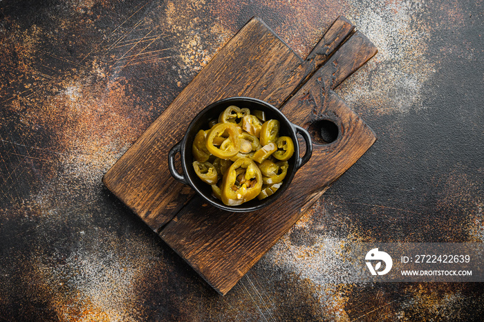 Jalapenos pickled and sliced, on old dark rustic background, top view flat lay  with copy space for text