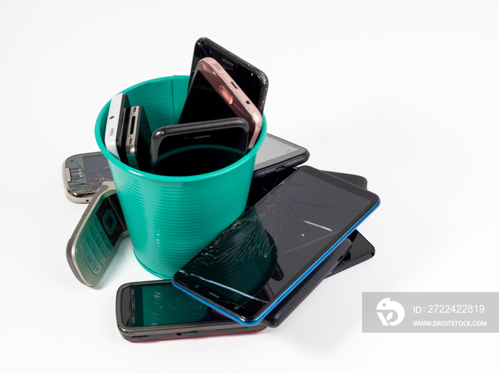 Full trash can of old smartphones on a white background.