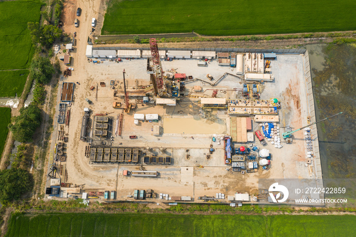 Oil and gas land drilling rig onshore in the middle of a rice field aerial view from a drone