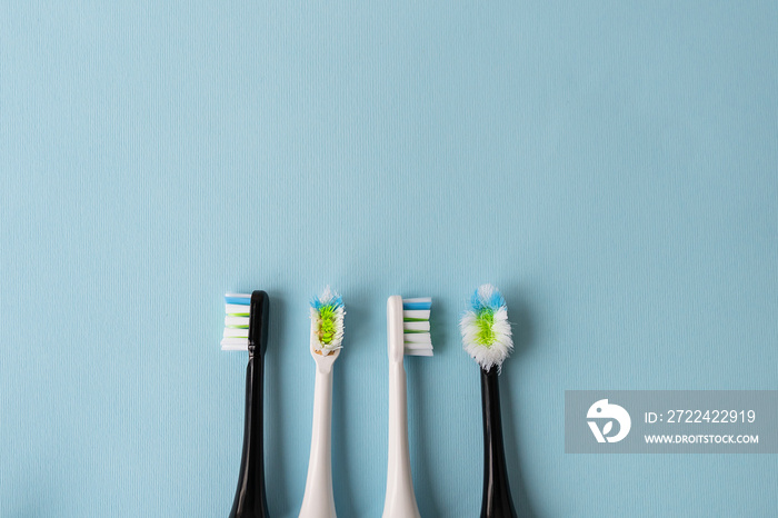 Modern electric toothbrush on a blue background, it’s time to change the brush - old and new brush attachment. Hygiene concept for daily oral care.