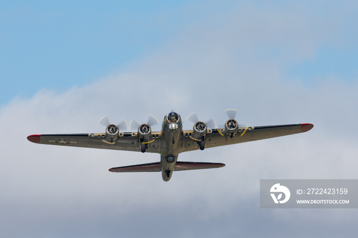 WWII bomber (B-17 Flying Fortress) raising against clouds