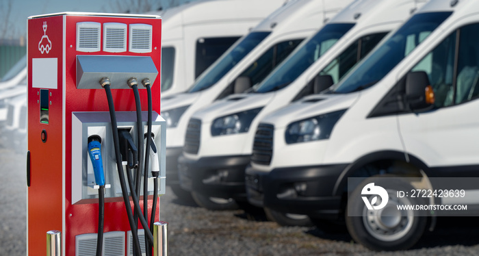 Electric vehicles charging station on a background of a row of vans. Concept