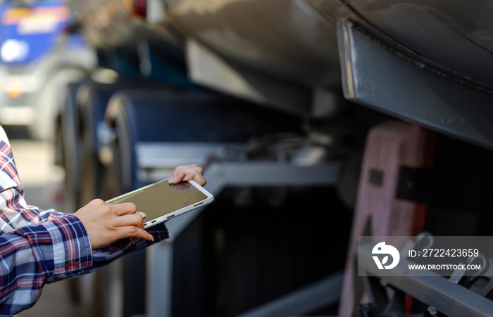 Truck drivers hand holding tablet checking the product list,Driver writing electronic log books,spot focus.