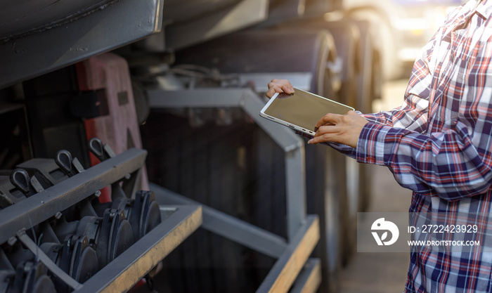 Truck drivers hand holding tablet checking the product list,Driver writing electronic log books,spot focus.