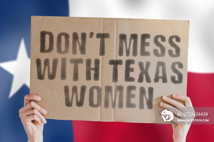 The phrase   Don’t mess with Texas women   on a banner in men’s hand with blurred Texans flag on the background. Protest. Street. Rally. March. Equality. Right