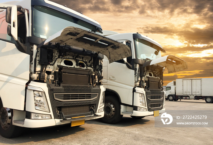 white semi trucks opening front the engine parking at sunset sky, freight industry logistics transportation.