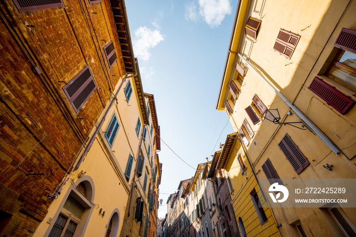 View on narrow and cozy street in the old town of Siena city in Italy. Concept of ancient architecture of the Tuscan region