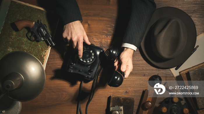 1950s style detective making a phone call at night