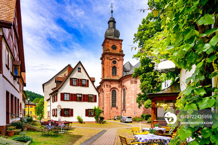 Narrow street with view of the church in the old town of Amorbach in Lower Franconia, Bavaria, Germany