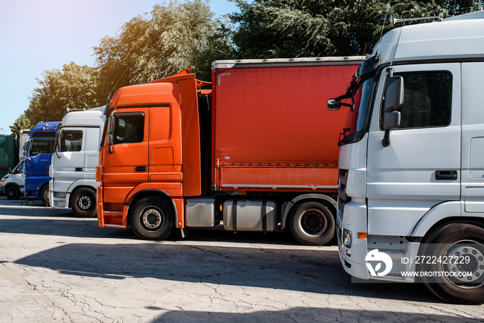 Lateral view of trucks staying in the truck parking on the sunset.