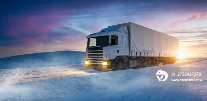 LKW in weiter Winterlandschaft bei Sonnenaufgang