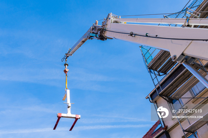 Construction crane boom with a load feeder.