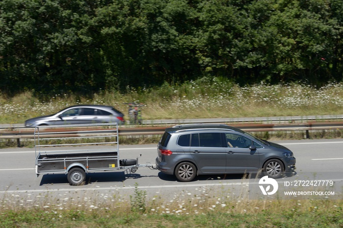 Voiture tractant une remorque sur une voie rapide