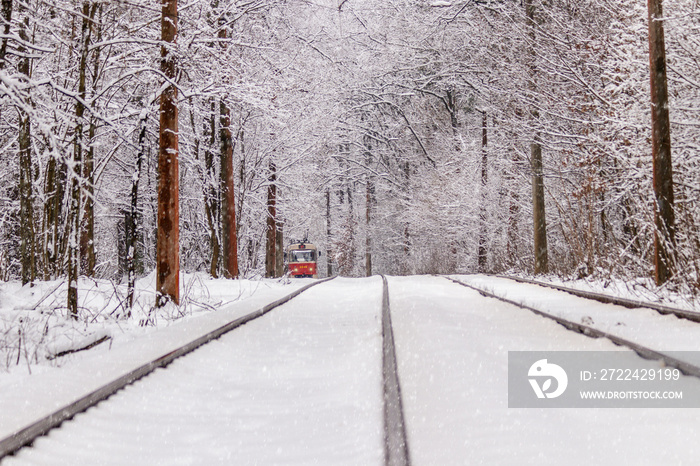 An old tram moving through a winter forest