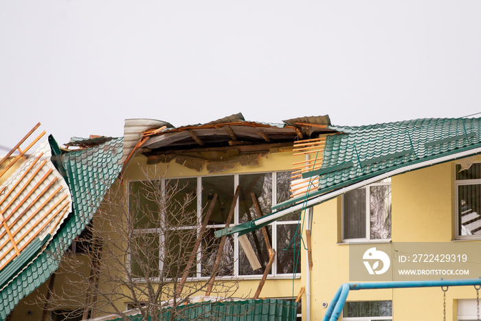 Damaged roof of a building. Strong wind, tornado, storm concept