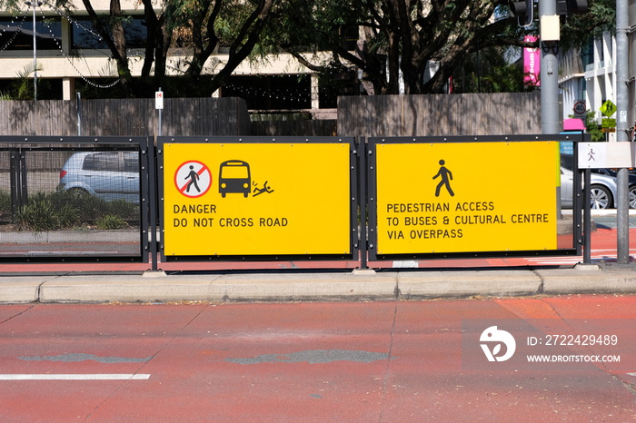 A danger do not cross road yellow warning sign at the bus station to warn pedestrians in Brisbane CBD, Australia