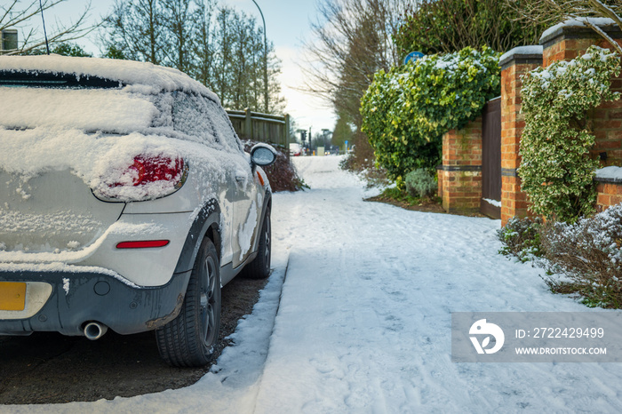 Car parked on winter snow road in town in england uk during covid lockdown