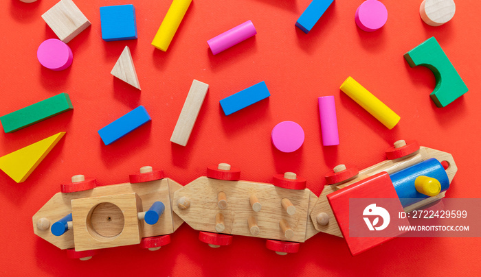 Train toy and wooden colorful blocks on red color background