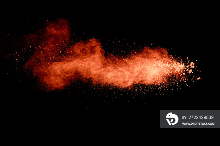 Abstract orange powder explosion on black background. Freeze motion of orange powder splash.