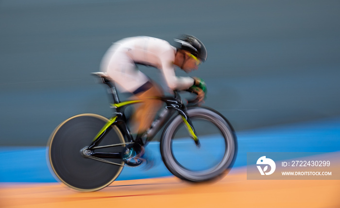 Profile blurred motion of cyclist competing indoor