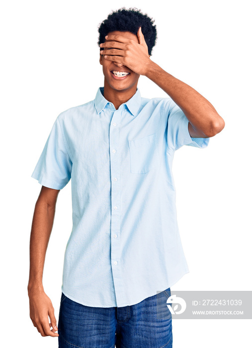 Young african american man wearing casual clothes smiling and laughing with hand on face covering eyes for surprise. blind concept.