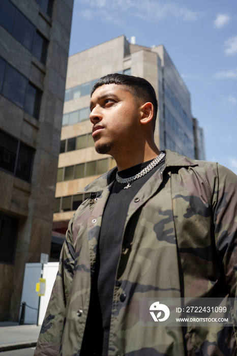 Young man wearing camouflage jacket and necklace