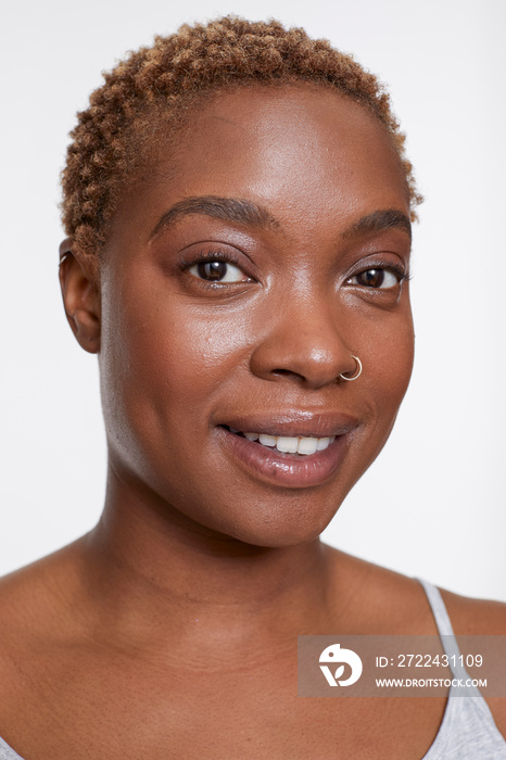 Studio portrait of smiling woman with nose ring