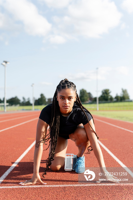 Female athlete preparing to run at stadium