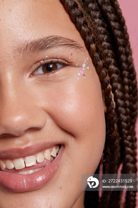 Close-up of smiling girl with decorative stickers on face