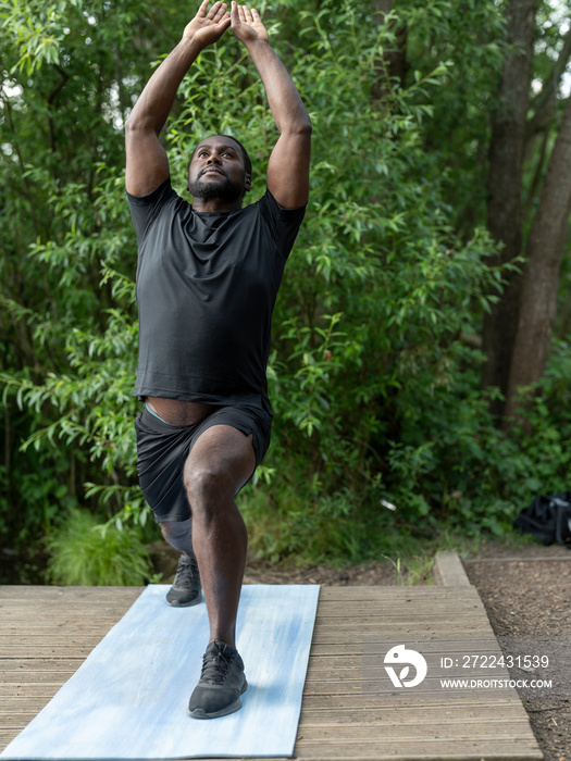 Man practicing yoga in park