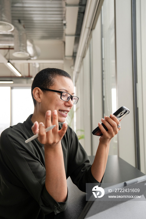 Woman using digital tablet and phone in office