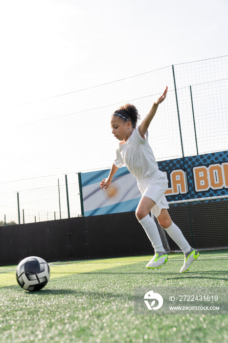 Girl (6-7) playing soccer on soccer field