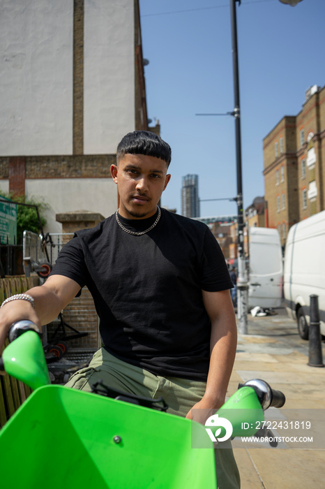 Man sitting on bike in city and looking at camera