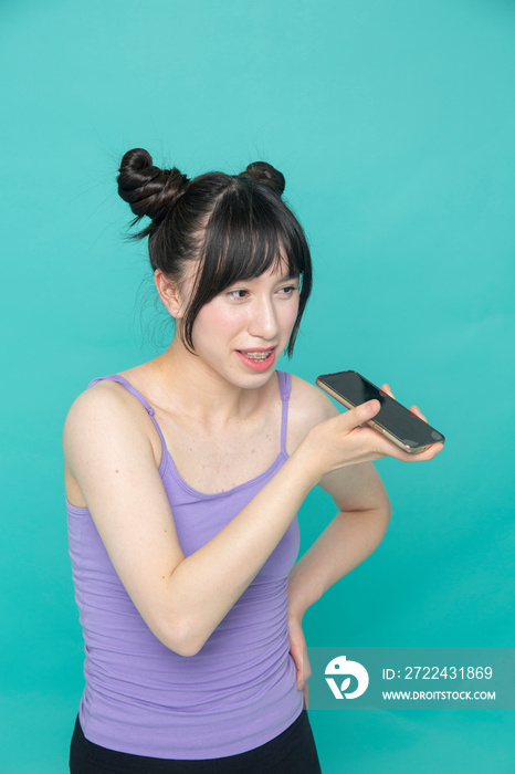 Studio shot of smiling girl talking on smart phone