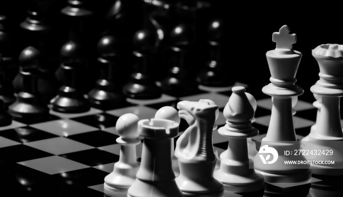 Close up of Chess pieces on a reflective mirror board surface wi