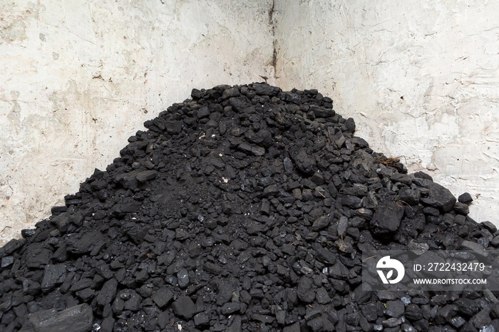 Black coal lying on a pile in house basement